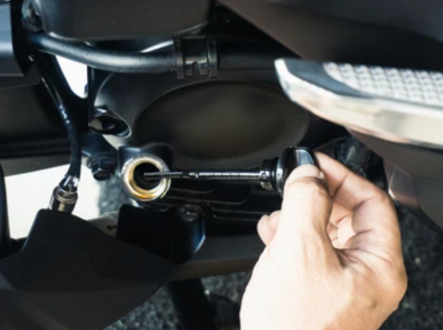 Checking motorcycle engine oil level with dipstick