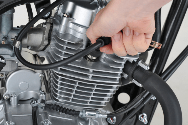 Man pulling out spark plug cable from the engine