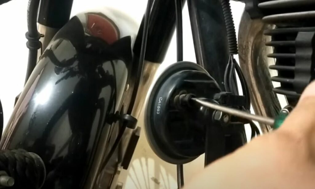 Motorcycle horn locknut tightening with a screwdriver