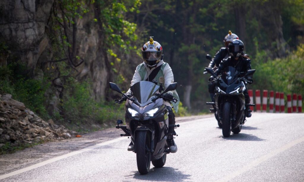 Motorcycle riders riding on road with helmet on