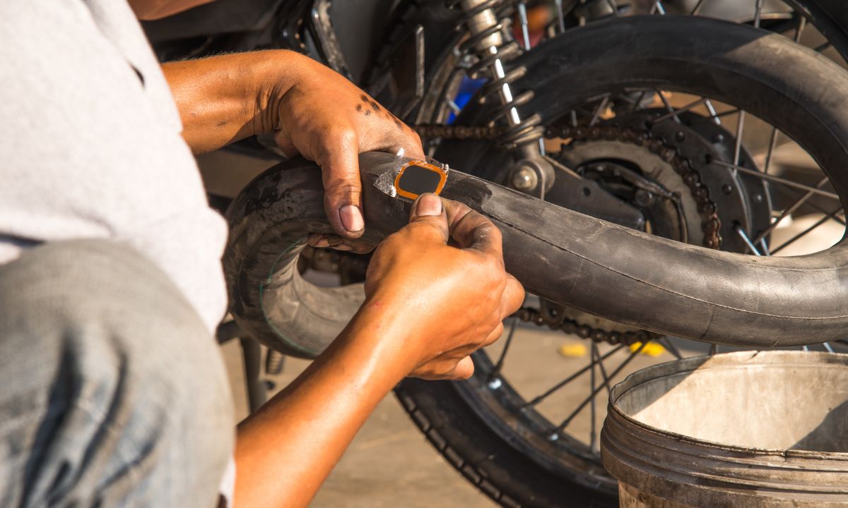 A man patching the tube of a motorcycle tire