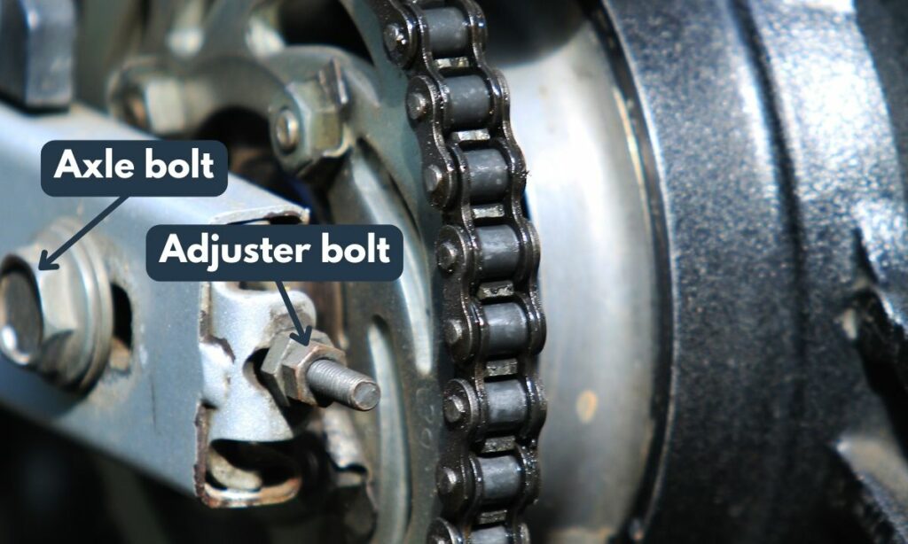 Axle and adjuster bolt on motorcycle chain side