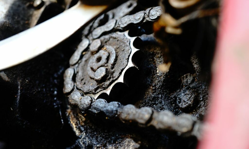 Sprocket and front sprocket area of motorcycle filled with dirt