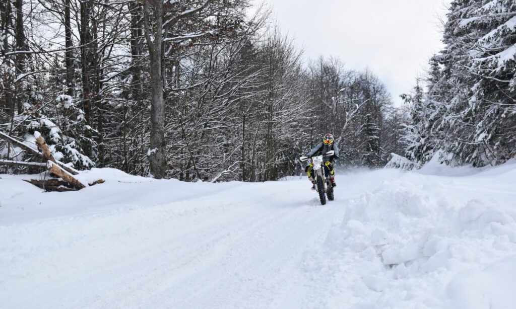 A man riding motorcycle on a snow road