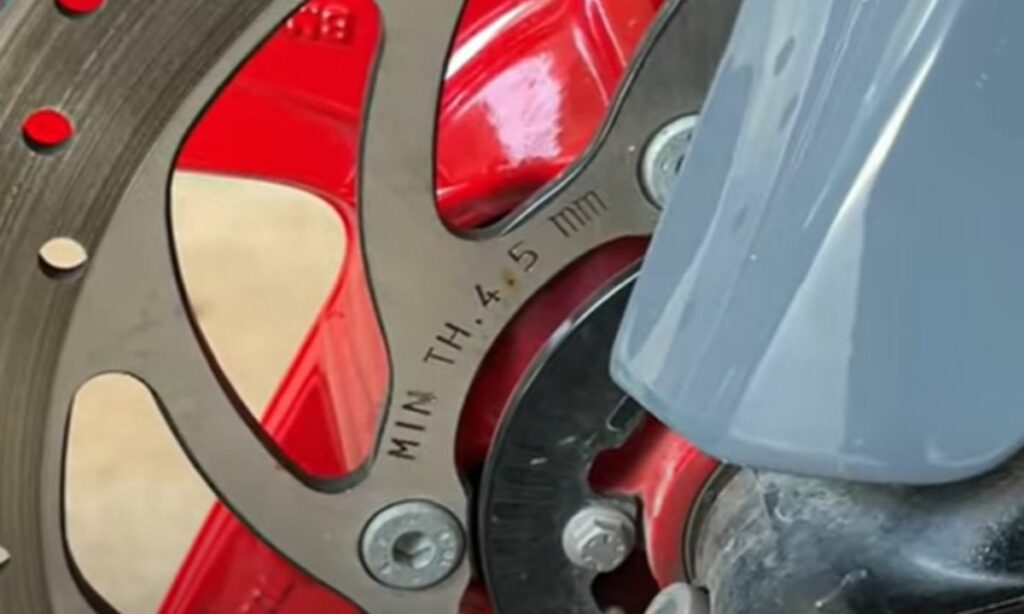 Motorcycle disc rotor with label on minimum thickness