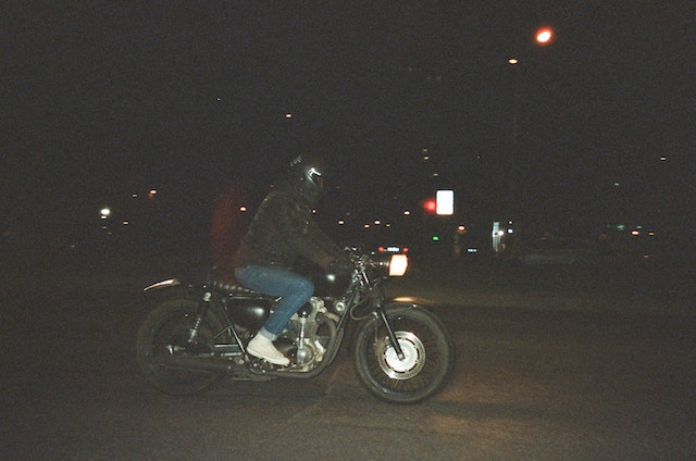 A guy riding a motorcycle at night