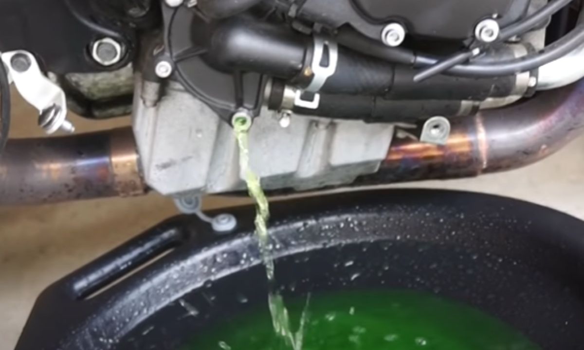 Draining the coolant from a motorcycle with the drain pan placed below