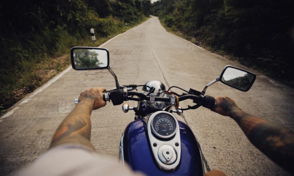 A rider gripping the motorcycle handlebar on road