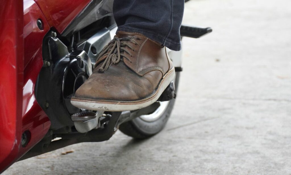 A rider's foot on motorcycle gear shifter