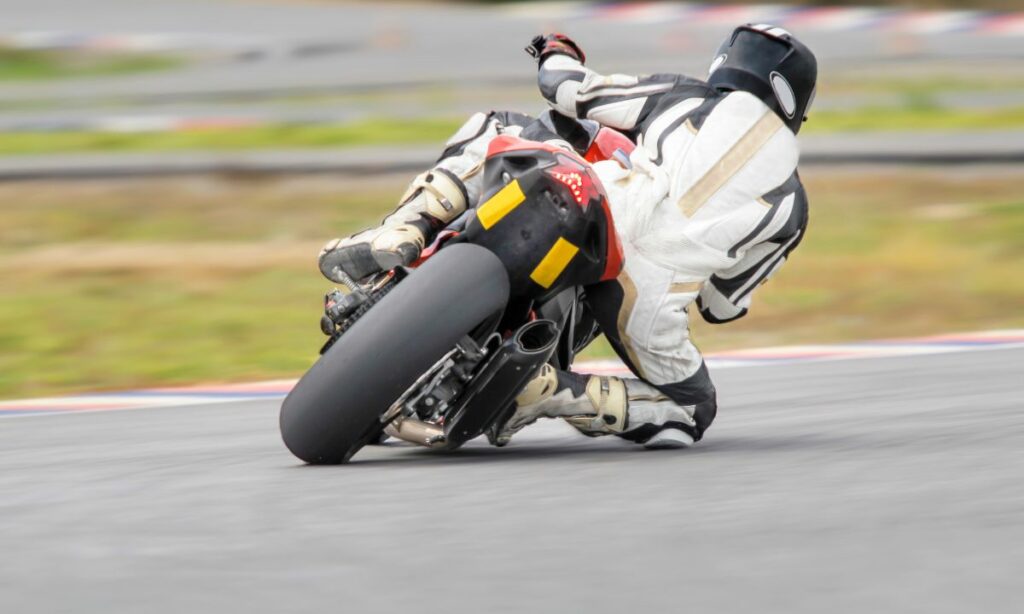 A motorcycle racer leaning his bike to the point of his knee scraping