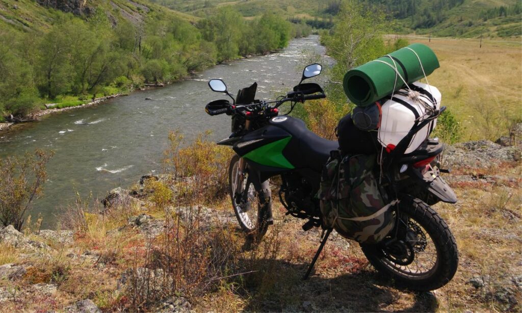 Motorcycle parked on the woods - carrying luggage and extra fuel in a can