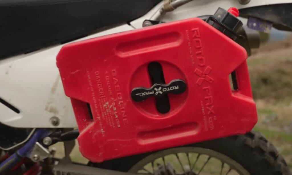 Red Rotopax can fitted on a motorcycle to store extra gasoline