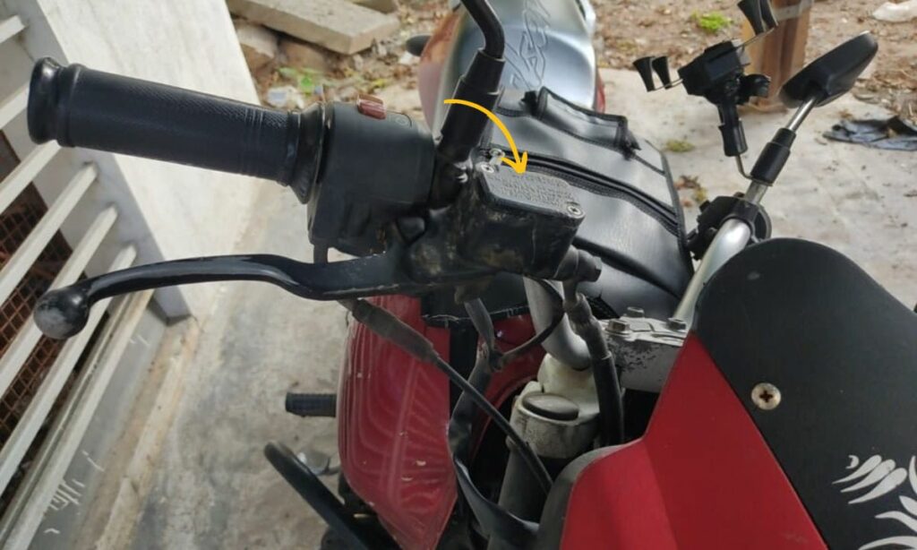Arrow pointing towards brake fluid reservoir in a motorcycle